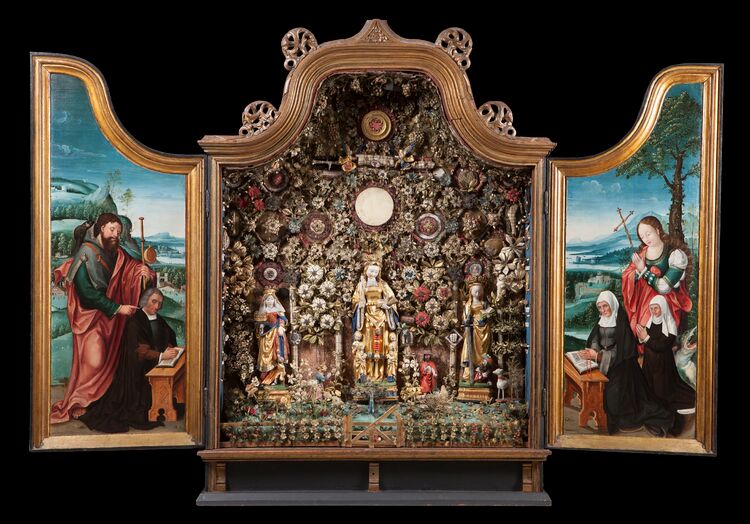 Een rijkelijk versierd retabelkastje met beschilderde deuren.